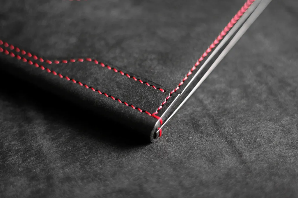 détail couture point sellier fil rouge